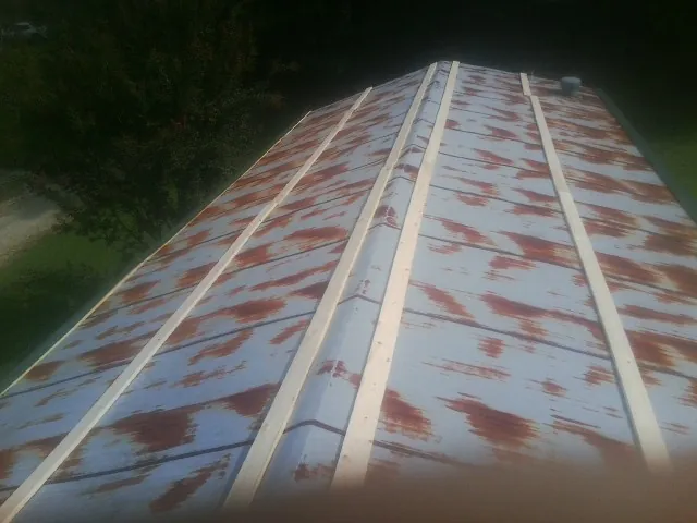 Rusted metal roof panels with new wood purlins before replacement — Storm Damage Roof Repair in Rushville by Roofing Brothers